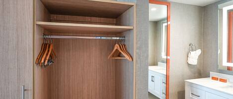 Un baño moderno con tocador de madera, un espejo grande y un perchero para toallas.