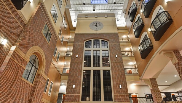 A multi-level atrium with a central clock, brick walls, and balconies.
