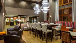 A hotel lobby with a reception desk, seating area, and a large dining table. - Hampton Inn & Suites Austin Cedar Park-Lakeline (Austin)