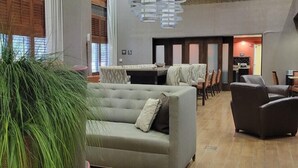 A spacious lobby with a grey sofa, a large potted plant, and a modern chandelier. - Hampton Inn & Suites Austin Cedar Park-Lakeline (Austin)