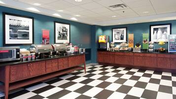 A breakfast bar with a checkered floor, a microwave, and various food items.