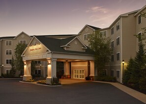 A hotel with a covered entrance, multiple floors, and a landscaped driveway. - Hampton Inn & Suites North Conway (North Conway)