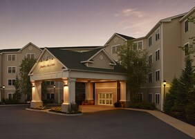 A hotel with a covered entrance, multiple floors, and a landscaped driveway.