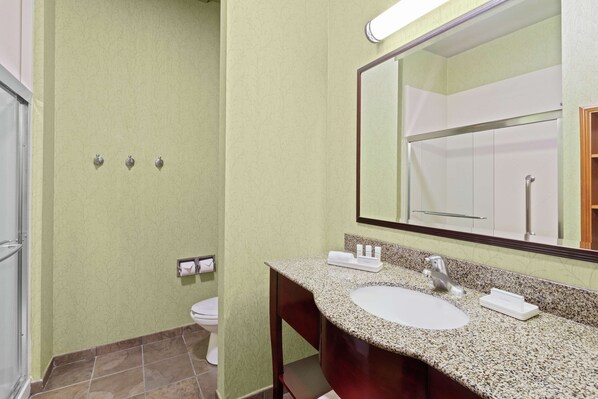 A bathroom with a sink, mirror, and toilet.