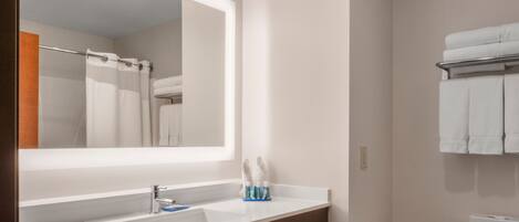 A bathroom with a white sink, a mirror, and a toilet.
