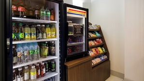 Una vetrina refrigerata con diverse bevande e un cartello per il negozio di articoli vari.