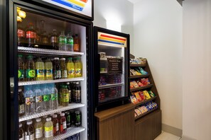 A refrigerated display case with various beverages and a sign for the Sundries Shop. - Holiday Inn Express and Suites Newton by IHG (Newton)