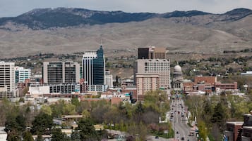 A cityscape with modern buildings, a prominent bank, and a mountain backdrop.