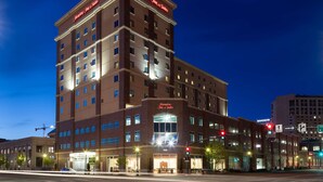 A multi-story hotel with a prominent sign reading "Hampton Inn & Suites."