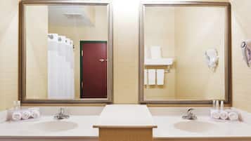 Un baño de hotel con dos lavamanos, un espejo y un perchero para toallas.