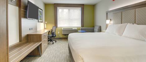 A hotel room with a bed, desk, chair, TV, and window.