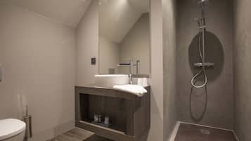 Een moderne badkamer met een wastafel, een douche en een toilet.