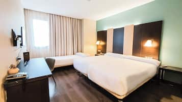 Une chambre d’hôtel avec deux lits, un bureau et une chaise.