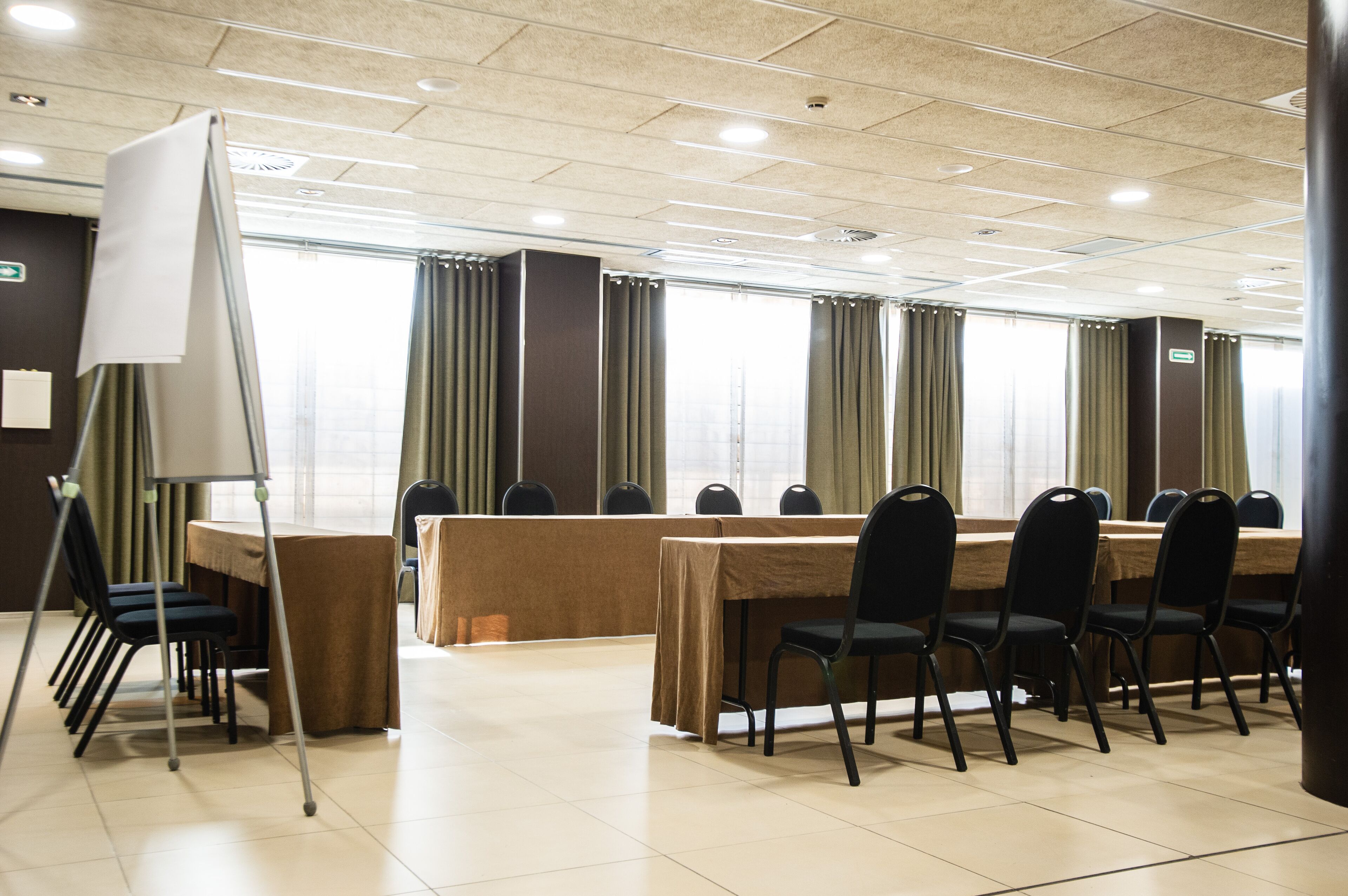 A conference room with a long table, chairs, and a whiteboard.