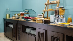 Tarjolla on runsas buffet, jossa on monenlaista ruokaa, kahvipiste ja mehupiste.