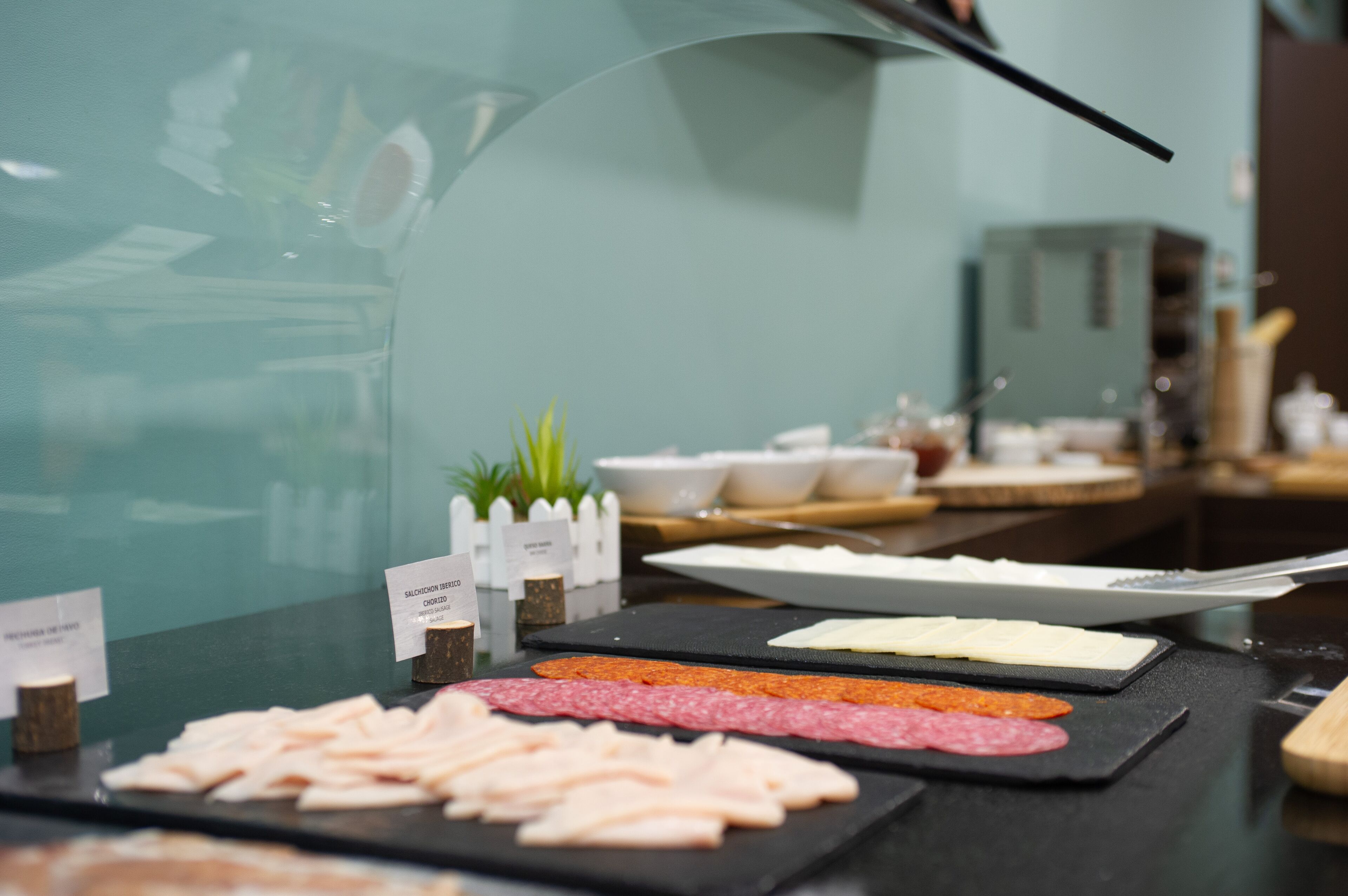 A buffet with various meats and cheeses.