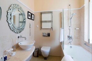 Un baño con lavamanos, inodoro y bañera.