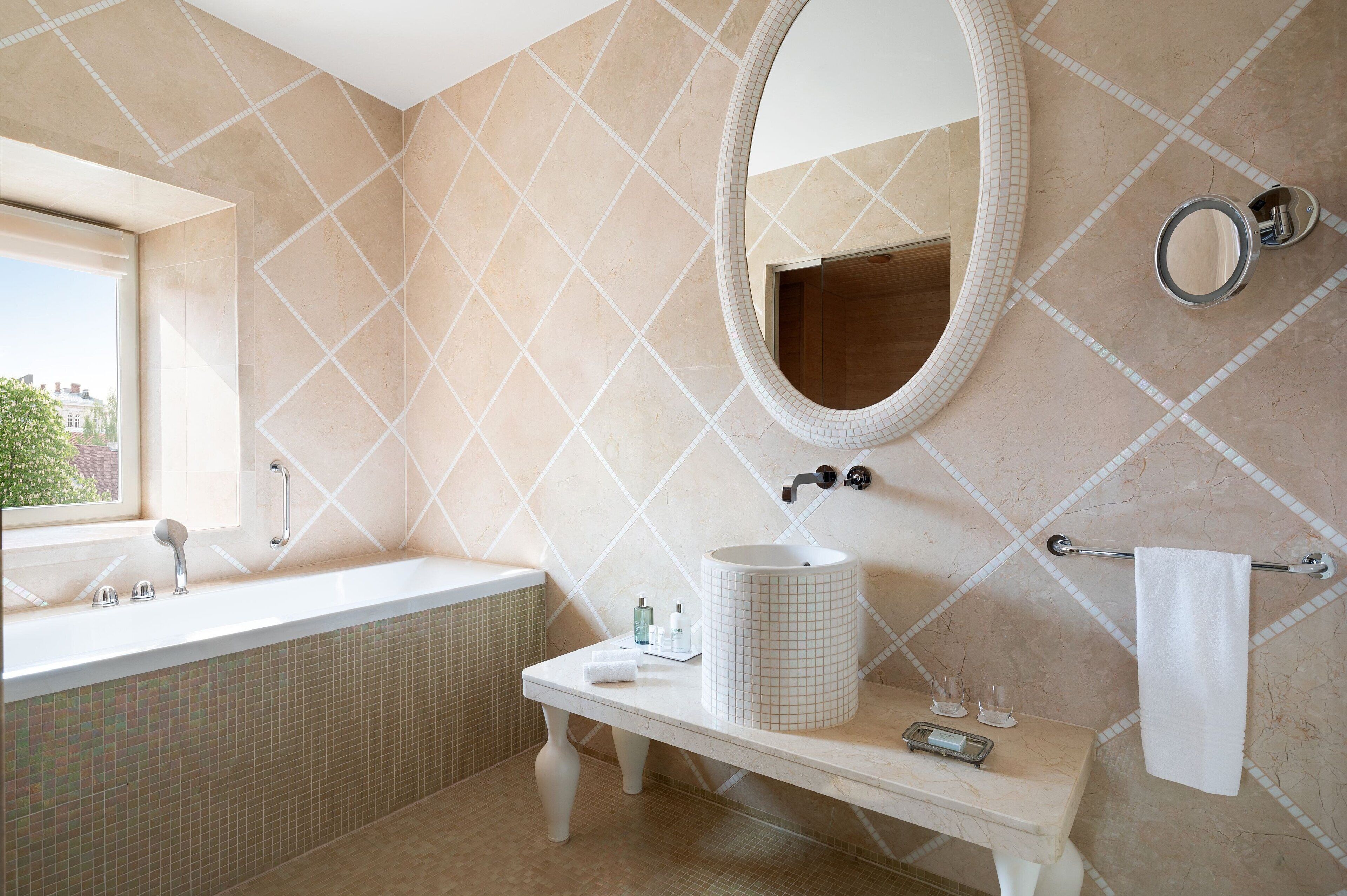 Une salle de bain avec une grande baignoire, un meuble-lavabo avec un évier, un miroir et un porte-serviettes.