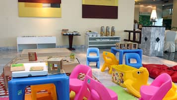 Children can play and learn in this interactive space with a play kitchen, tables, and chairs.