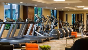 Una palestra con diverse tapis roulant, ellittiche e macchinari per pesi.
