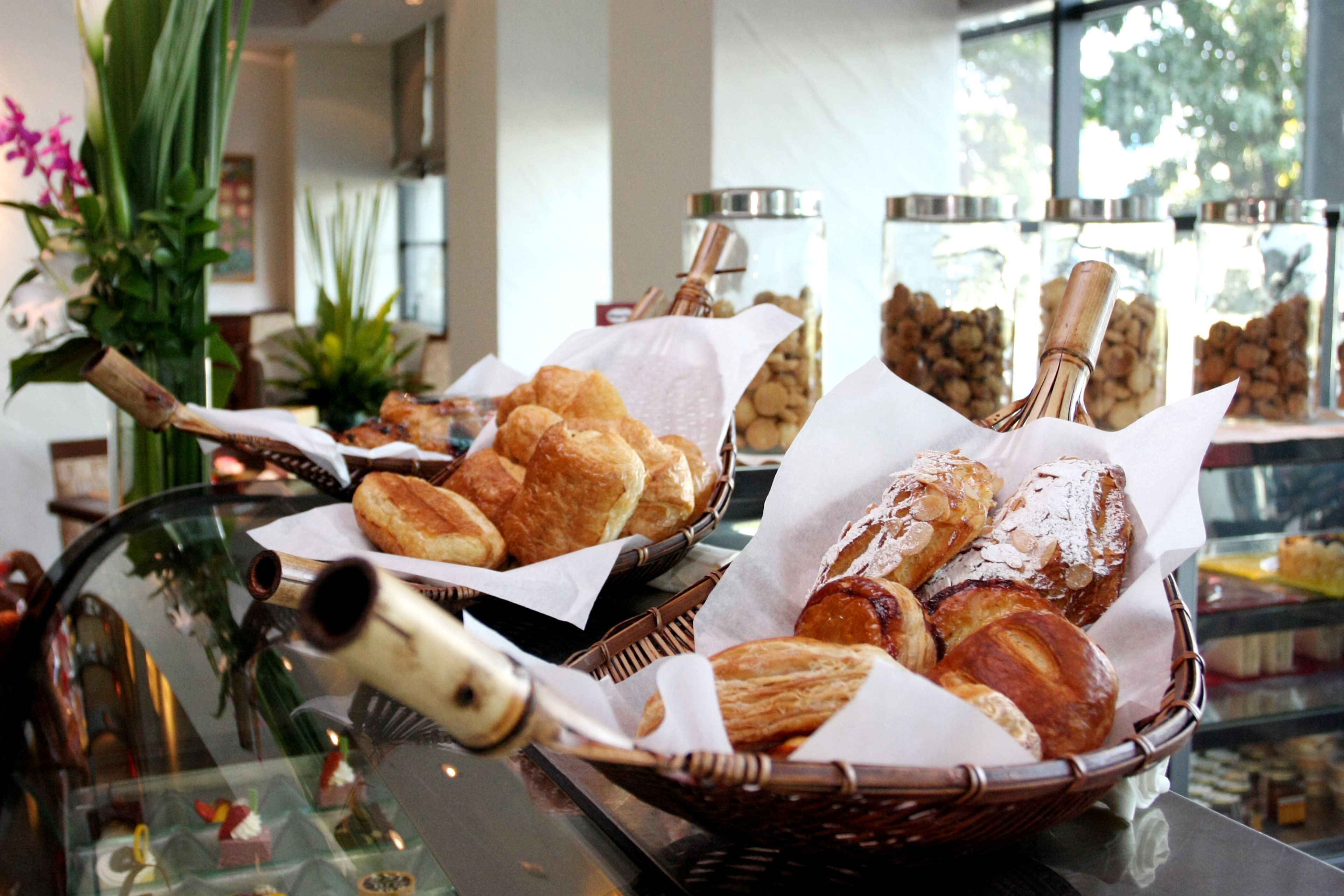 Un'esposizione di dolci in cesti e barattoli, probabilmente in una panetteria o caffetteria.
