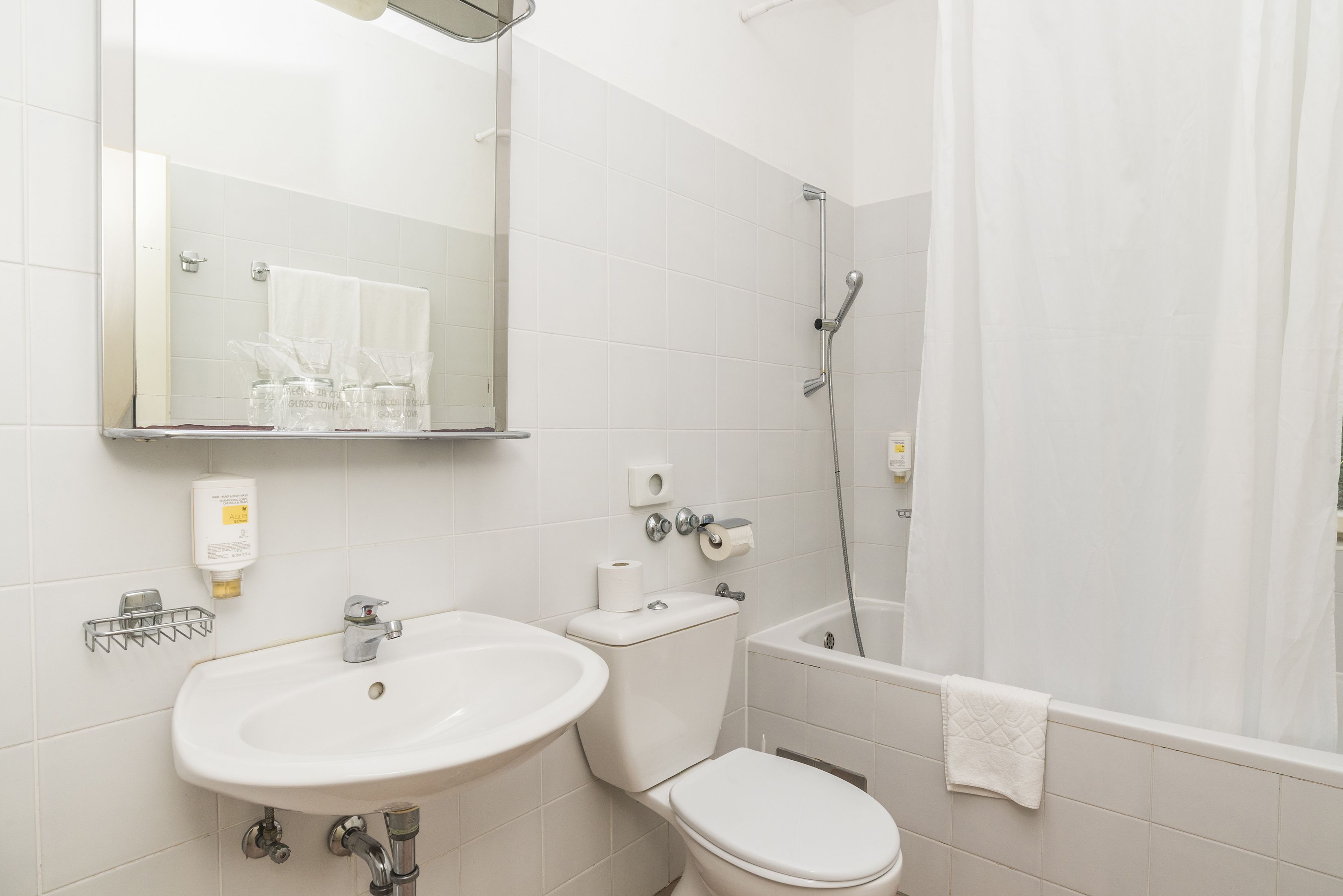 A bathroom with a sink, toilet, and shower.