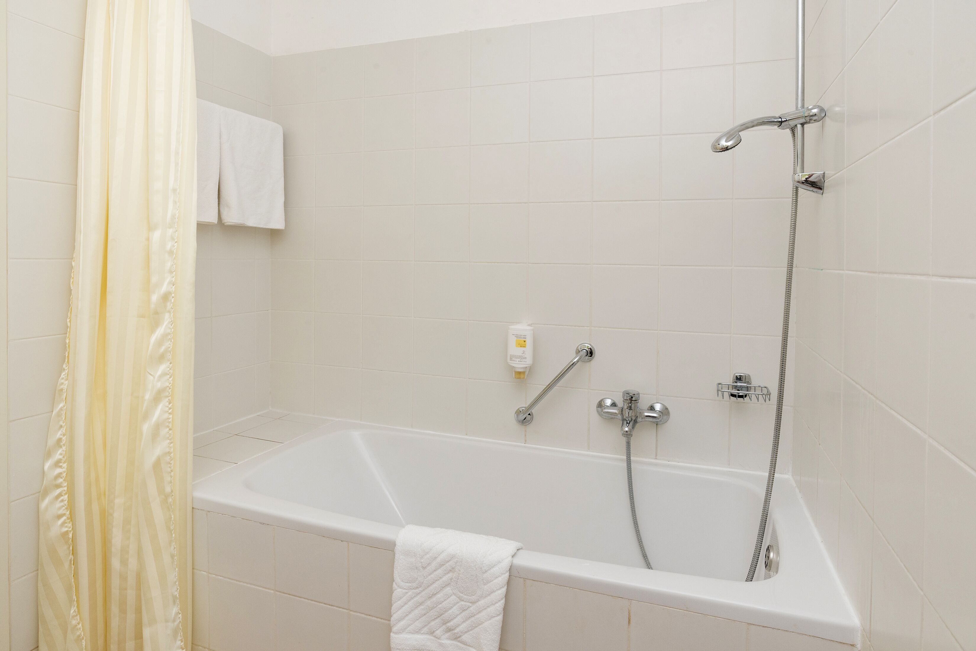 Un baño moderno con bañera, ducha y un perchero para toallas.