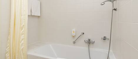 Un baño moderno con bañera, ducha y un perchero para toallas.