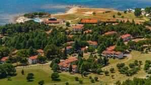 Un quartier résidentiel situé sur la côte, avec des maisons, une piscine et une plage.