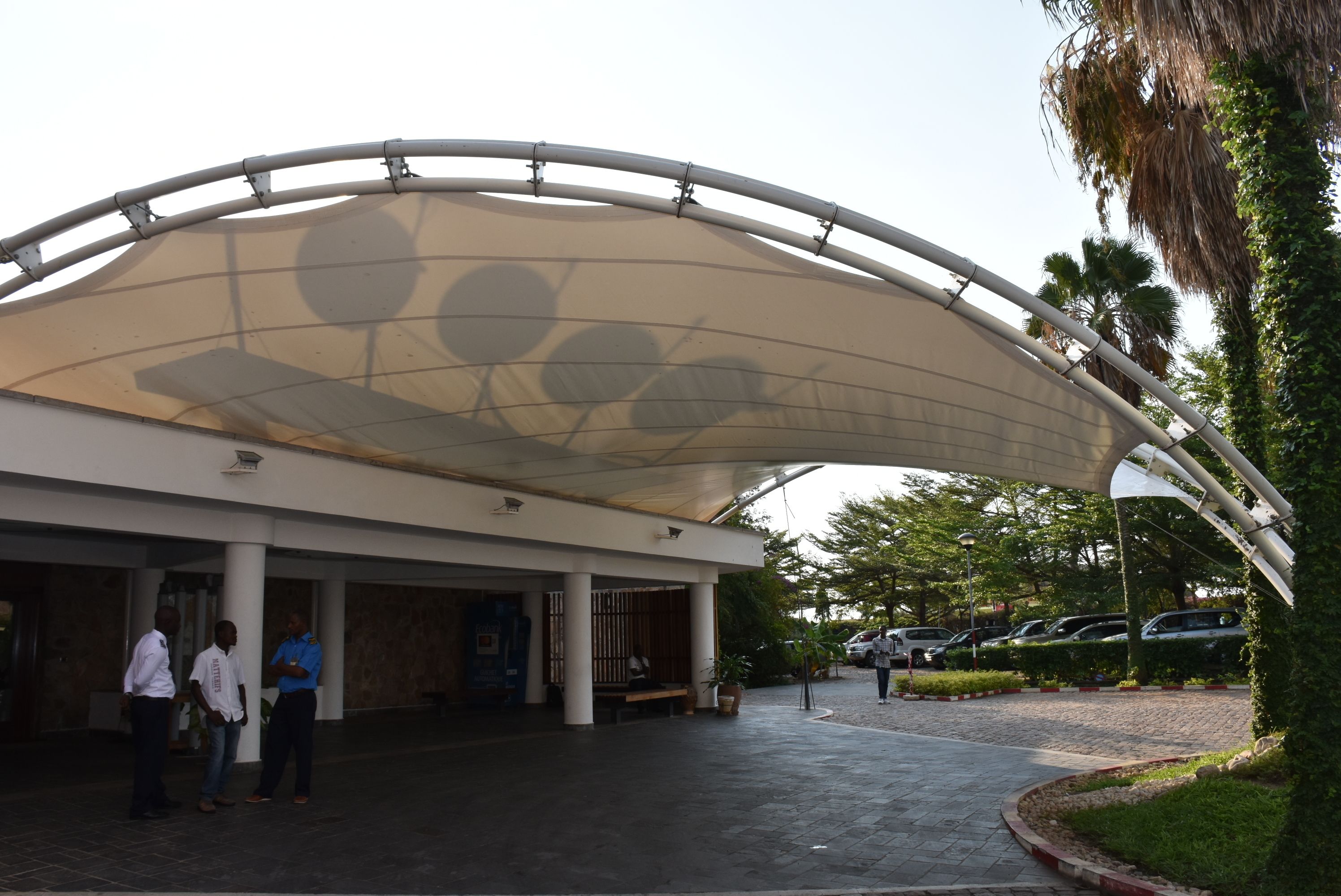 A modern building with a curved roof structure and a covered entrance area.