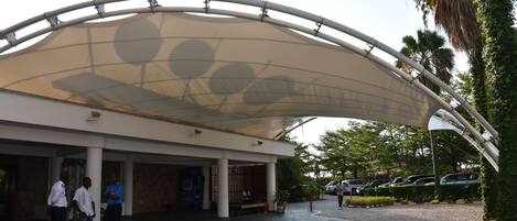 A modern building with a curved roof structure and a covered entrance area.