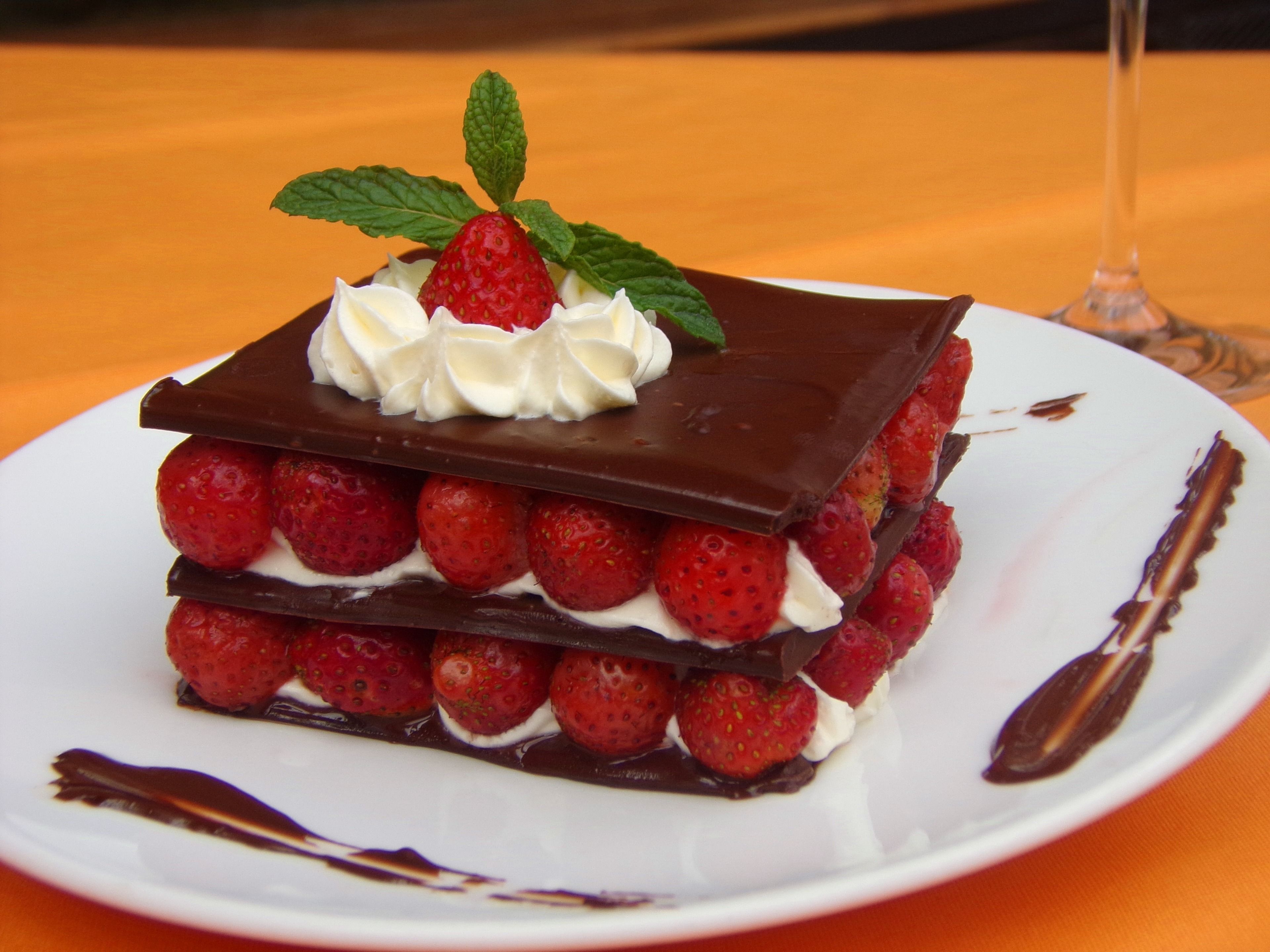 Un dessert aux fraises et au chocolat, servi dans une assiette blanche.