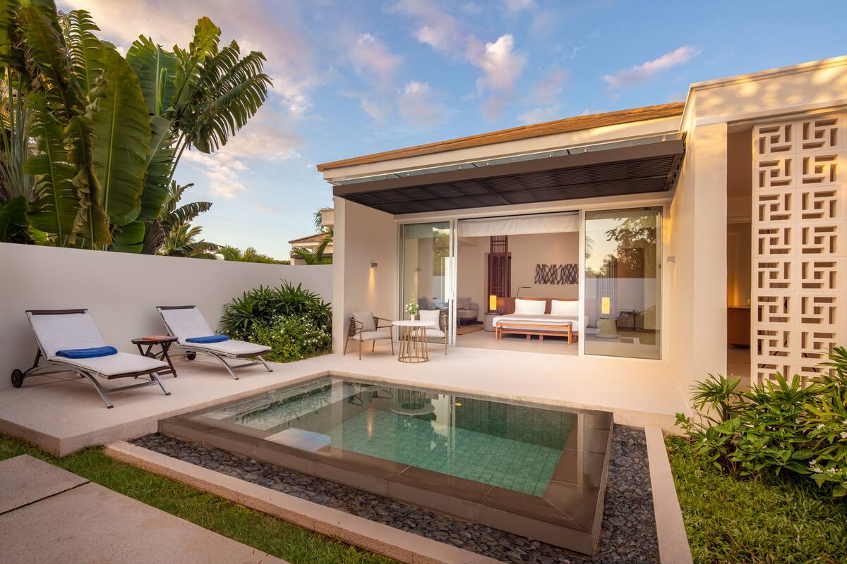 A modern house with a swimming pool, outdoor seating, and a patio area.