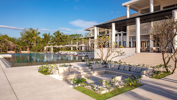 Um resort moderno com piscina, área de estar ao ar livre e um alpendre coberto.