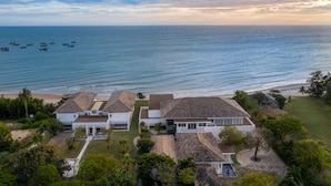 Um imóvel costeiro com vários edifícios, uma praia e barcos na água.