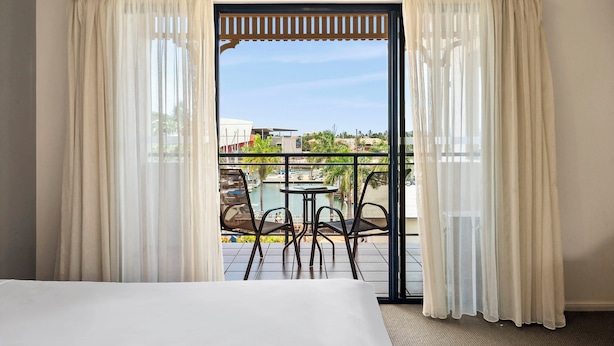 Ein Hotelzimmer mit Balkon, einem Bett und einem Tisch mit Stühlen.