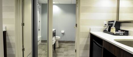 A modern bathroom with a large sink, a toilet, and a shower area.