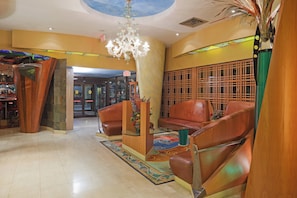 A lobby with a chandelier, leather seating, a patterned rug, and a decorative wall. - Holiday Inn Niagara Falls - By The Falls by IHG (Niagara Falls)