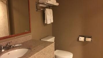 Un bagno con lavandino, WC e porta asciugamani.