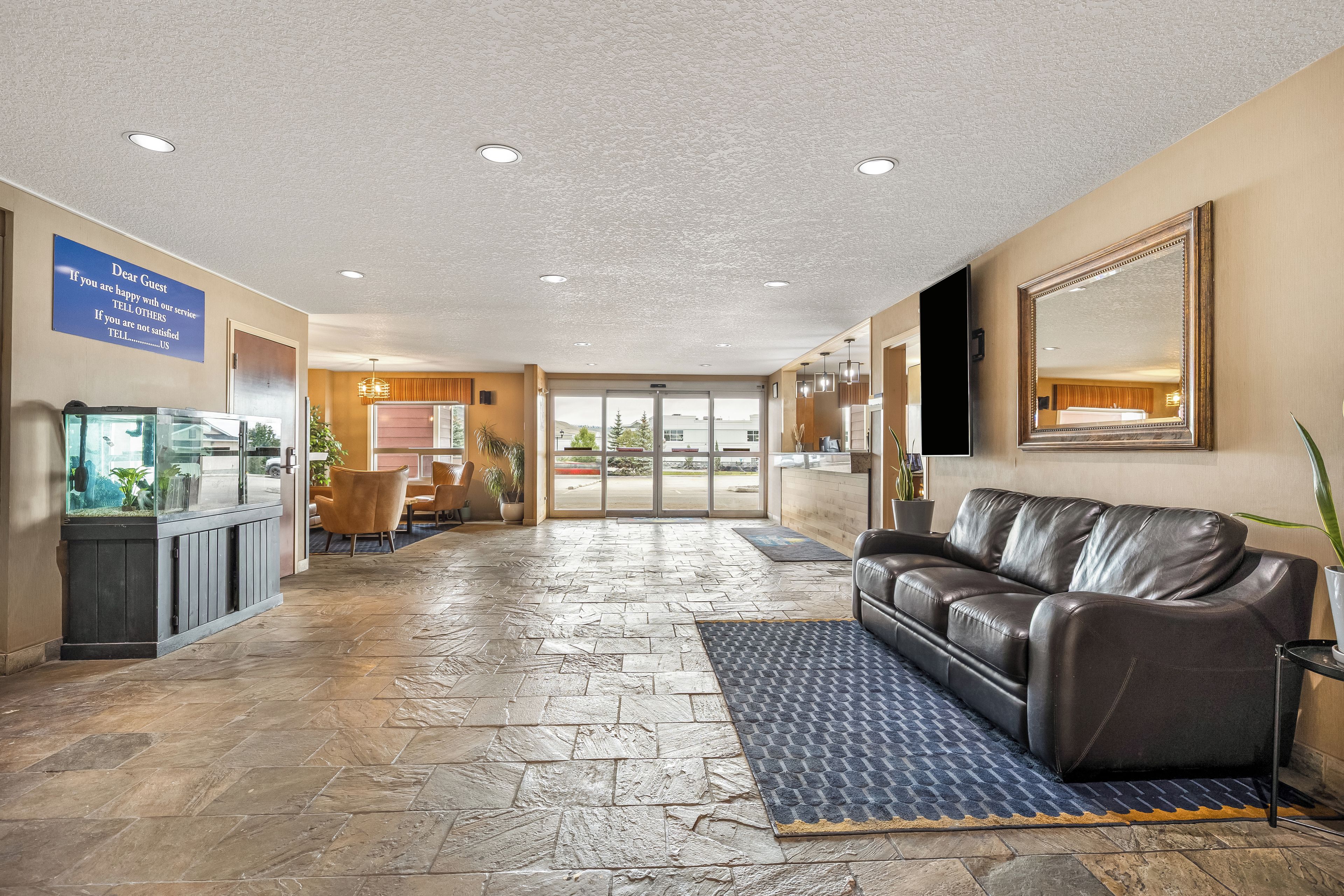 A lobby with a reception desk, a leather sofa, and a fish tank.