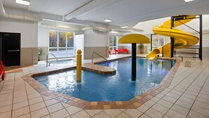 An indoor swimming pool with a yellow slide and a separate water feature. - Hôtel TERRA Laurentides (Sainte-Agathe-des-Monts)