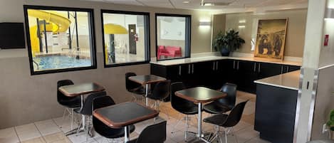 Ein modernes Interieur mit Küchenzeile, Esstischen und Stühlen.