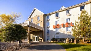 A multi-story hotel with a prominent 'HOTEL' sign, a covered entrance, and a stone facade. - Hôtel TERRA Laurentides (Sainte-Agathe-des-Monts)