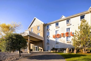 A multi-story hotel with a prominent 'HOTEL' sign, a covered entrance, and a stone facade.