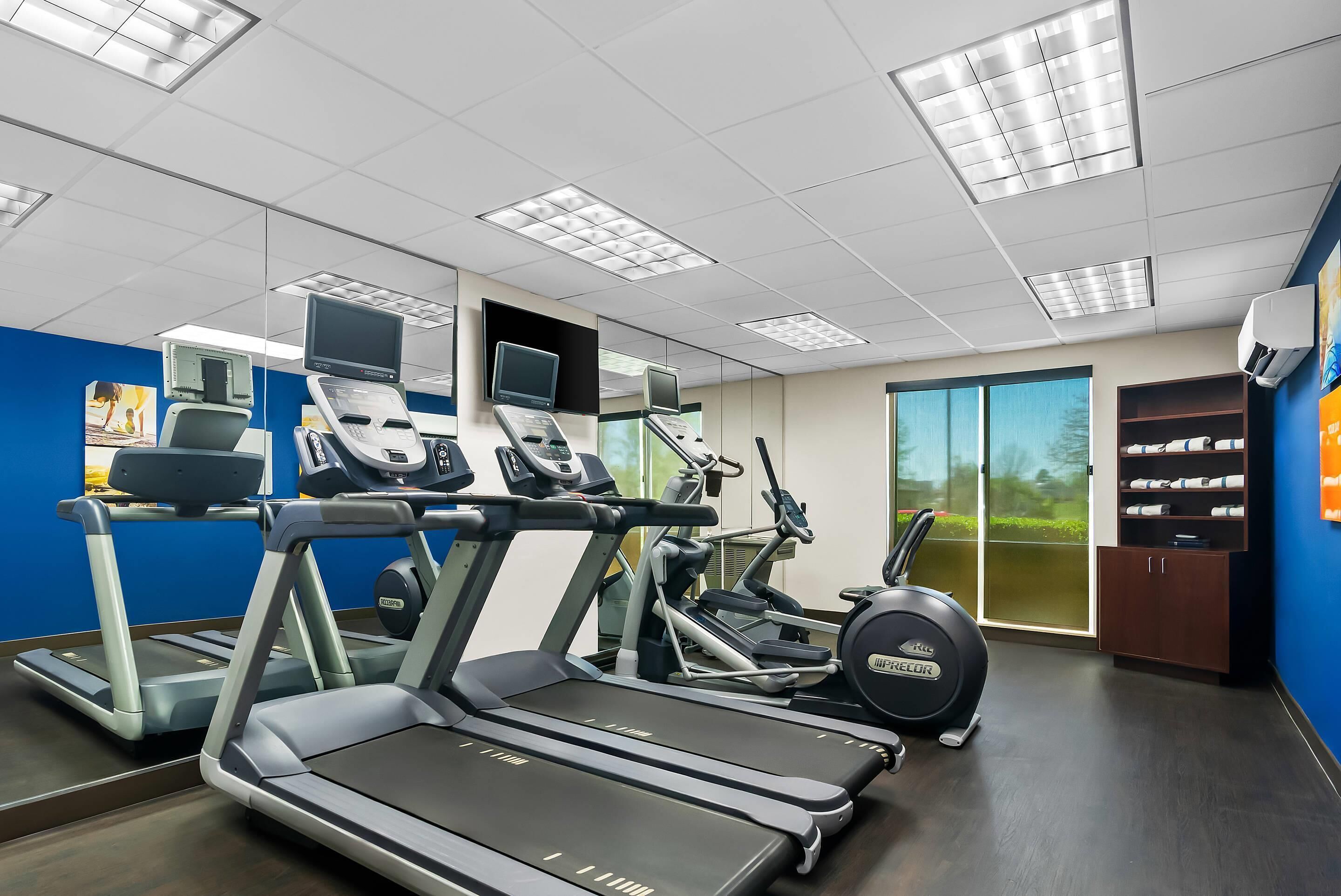 A gym with treadmills, elliptical machines, and a stationary bike.