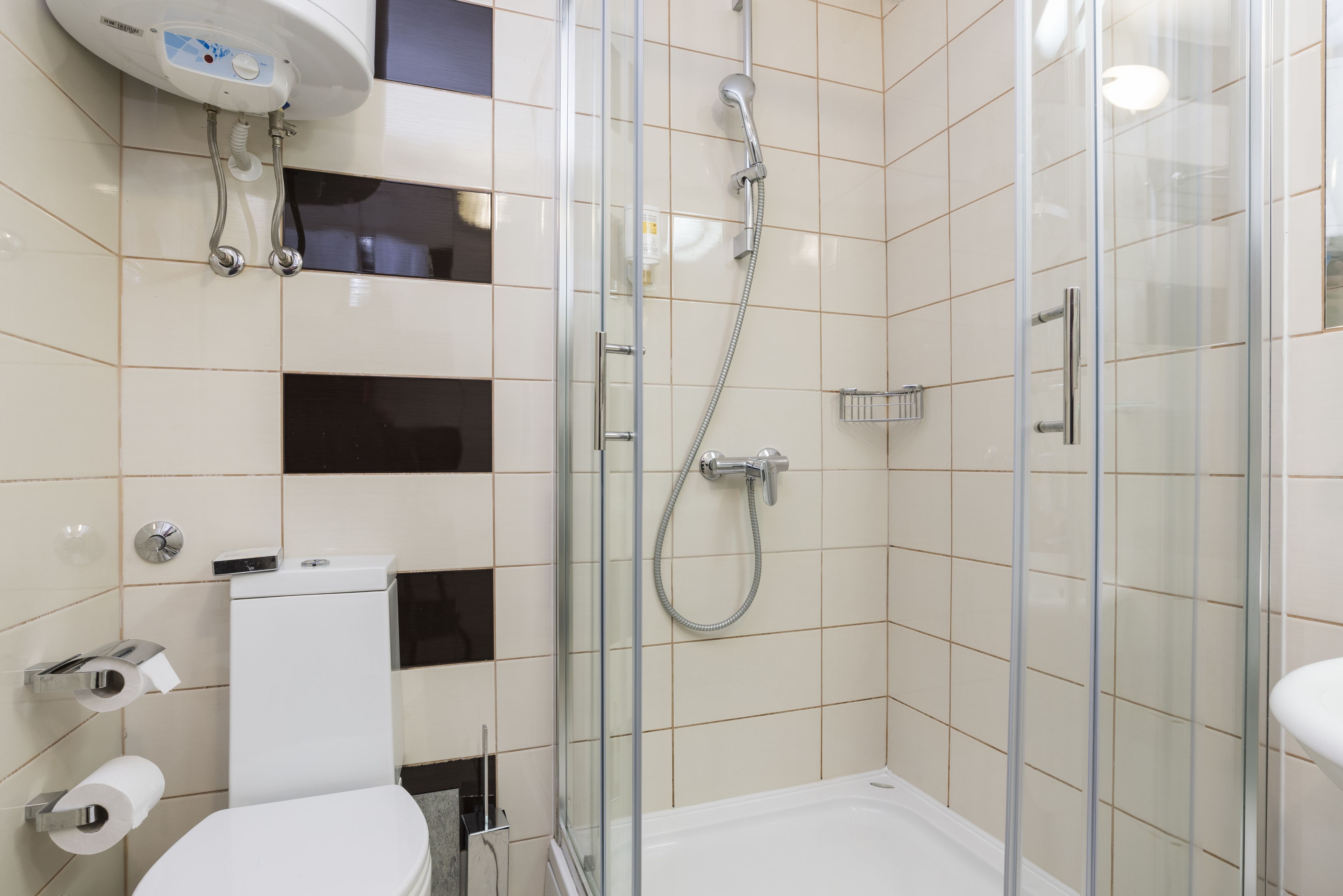 Ein modernes Badezimmer mit einer gläsernen Duschkabine, einer Toilette und einem Waschbecken.