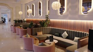 A modern lobby with a seating area featuring sofas and armchairs, a reception desk, and decorative lighting. - El Mouradi Gammarth (La Marsa)