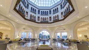 A spacious lobby with a central seating area, multiple balconies, and large windows providing natural light. - El Mouradi Gammarth (La Marsa)