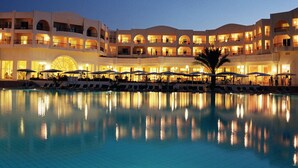 A hotel with multiple balconies, a swimming pool, and outdoor umbrellas. - El Mouradi Gammarth (La Marsa)