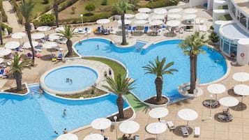 Relax by the multi-tiered pool surrounded by palm trees and sun loungers.